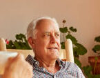 Senior couple sitting on rocking chairs. Man and woman are having tea on sunny day. They are resting at home.